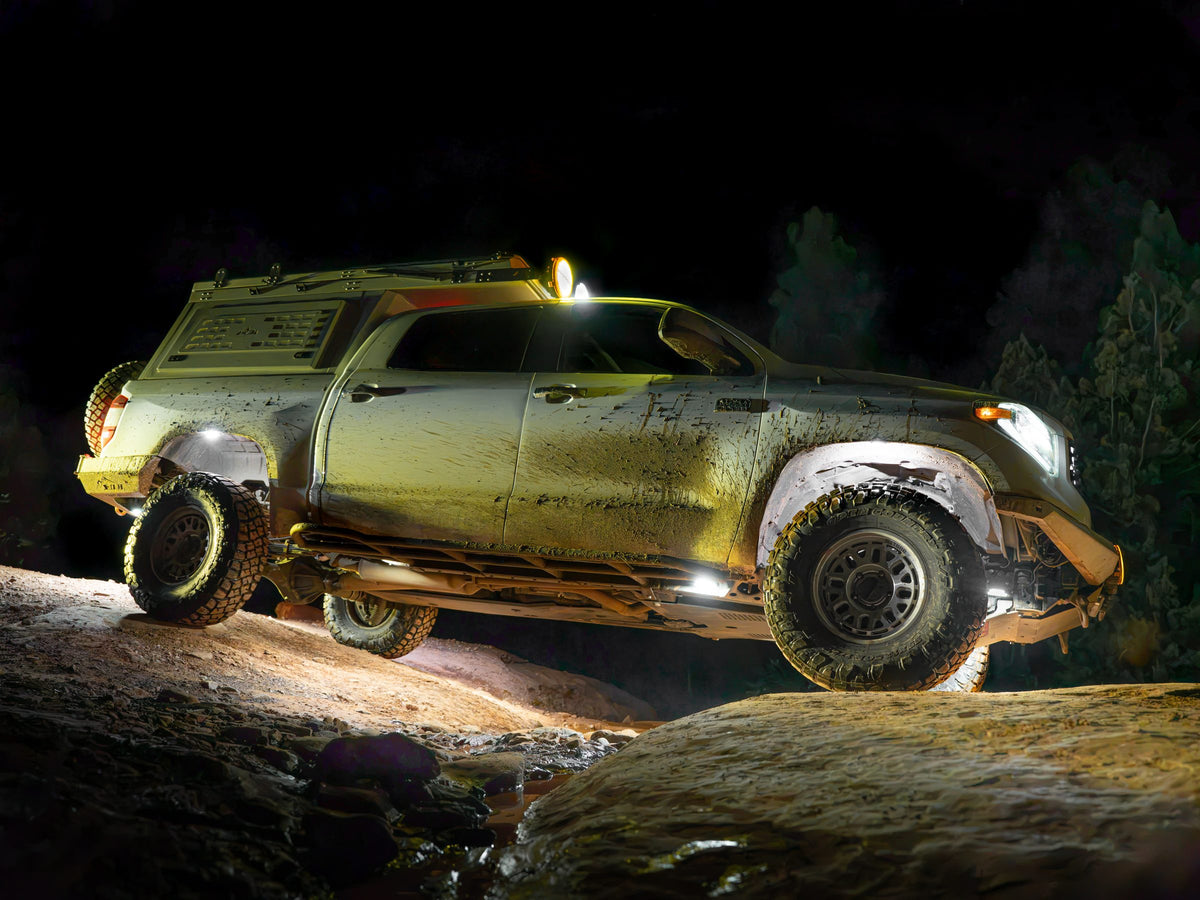 Toyota Tundra on a rocky trail at night, ground lit all around by Shadow Eliminator rock lights