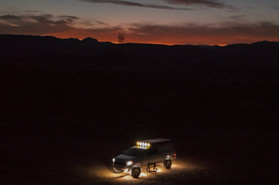 Truck lit up at dusk in the desert